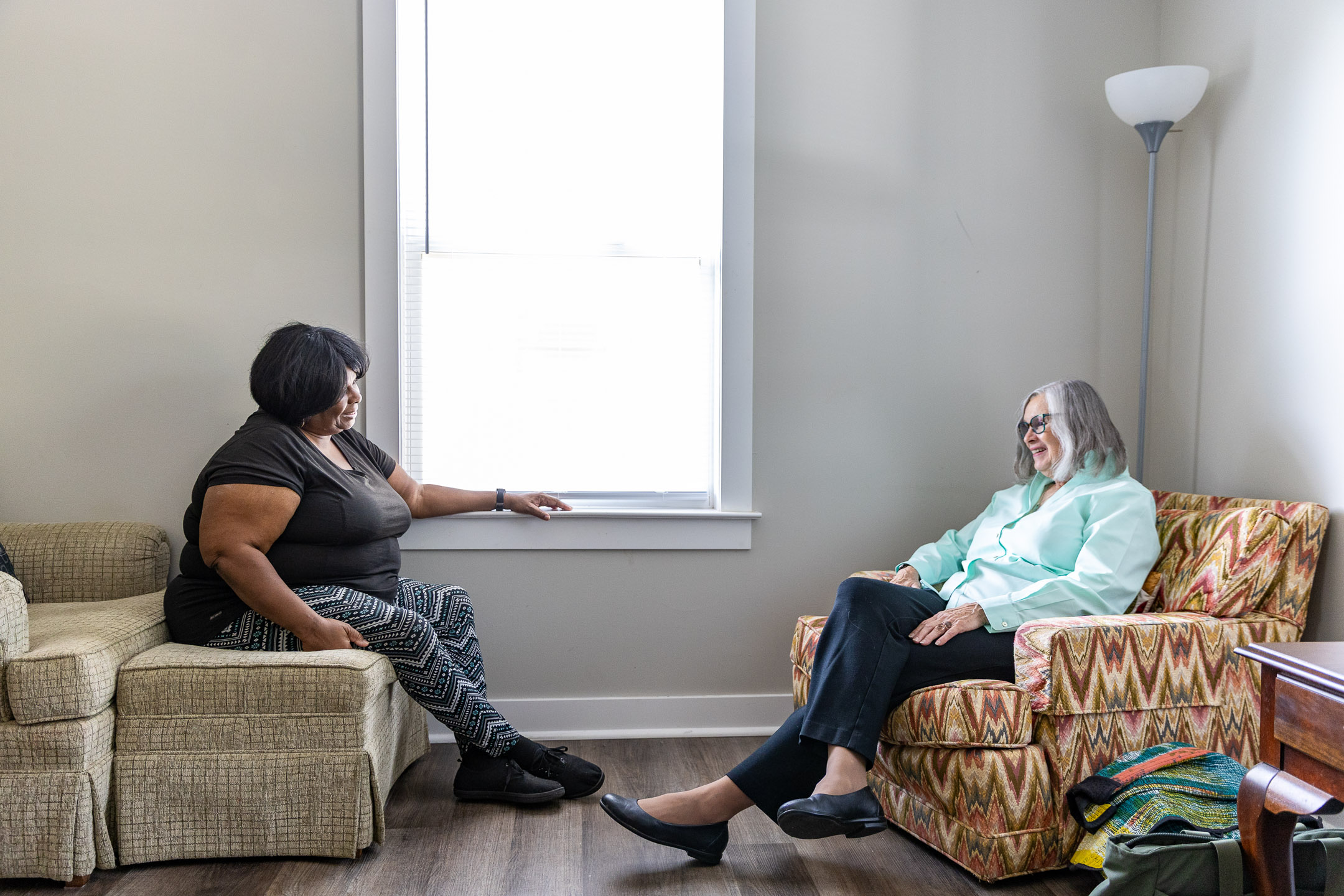 Barbara T. Lester, M.D., (right) and Denise share memories and a laugh in the living room.
