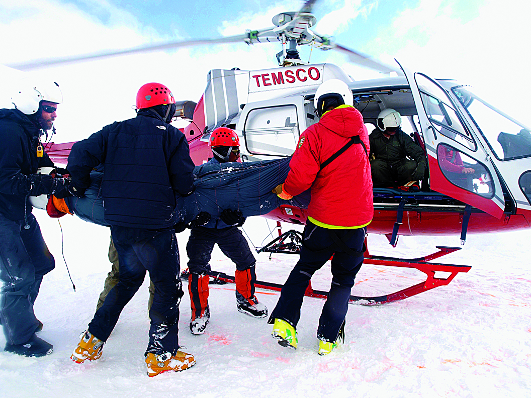 N. Stuart Harris, M'99 (far left), assists in a rescue on Denali. (Photo by Menno Boermans)