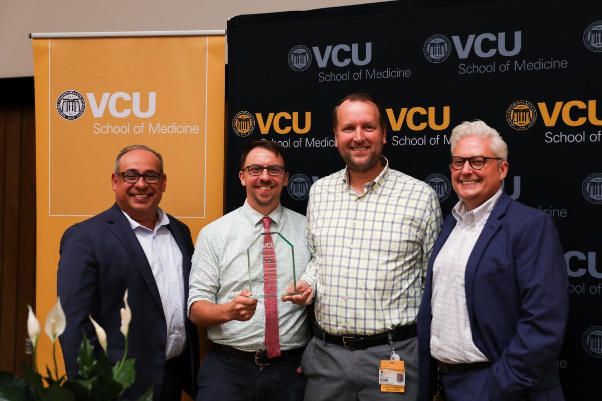 Arturo Saavedra, M.D., Ph.D, dean of the School of Medicine (far left) and Paul Peterson, interim senior associate dean for finance and administration (far right), with Excellence in Collaboration awardees Chuck Alexander (center left) and Eric Ellis at the 2025 Staff Distinction Awards (Photo by Arda Athman, School of Medicine)