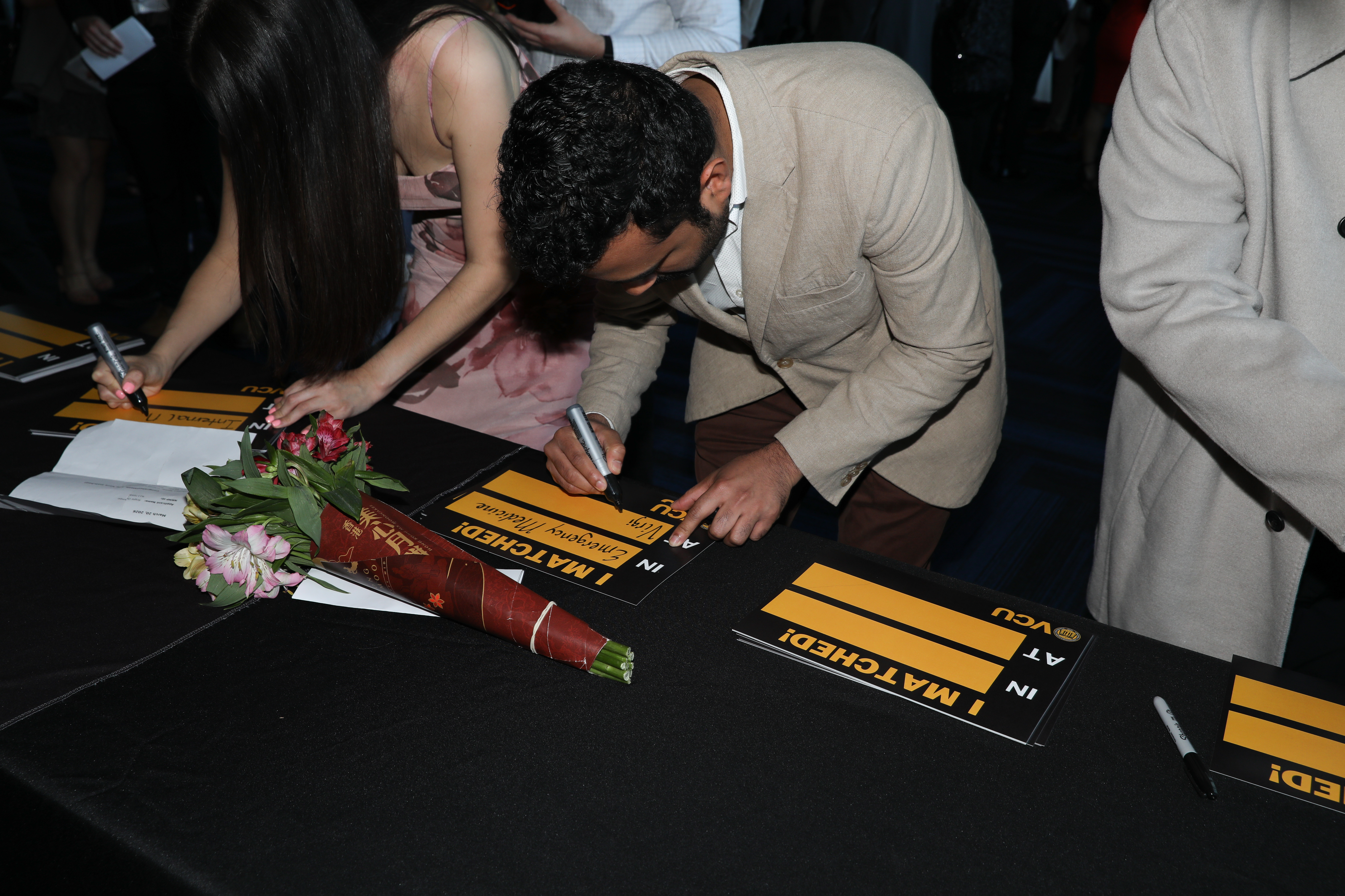 Student writes on sign at Match Day