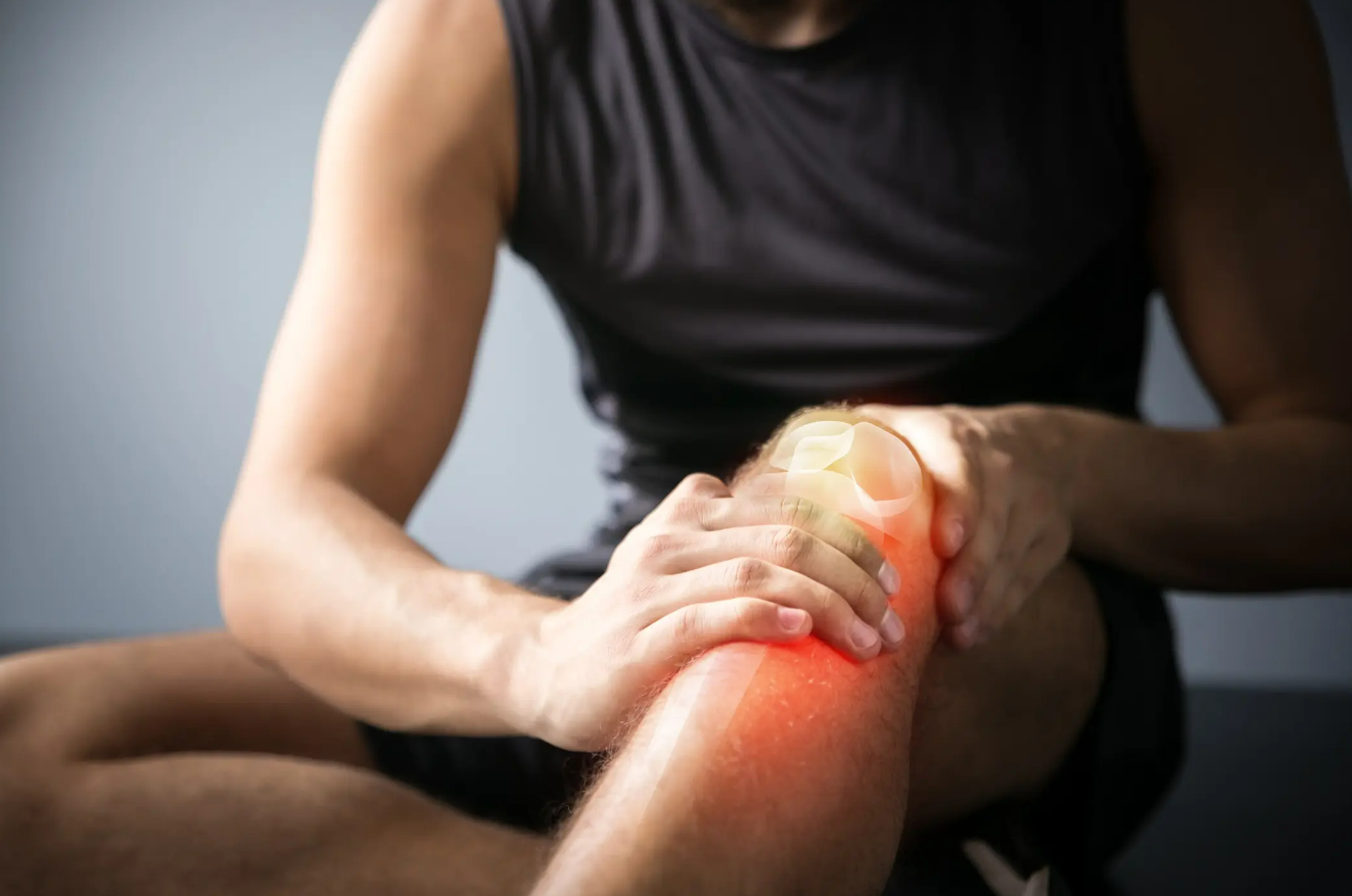 Person holding their knee due to chronic pain