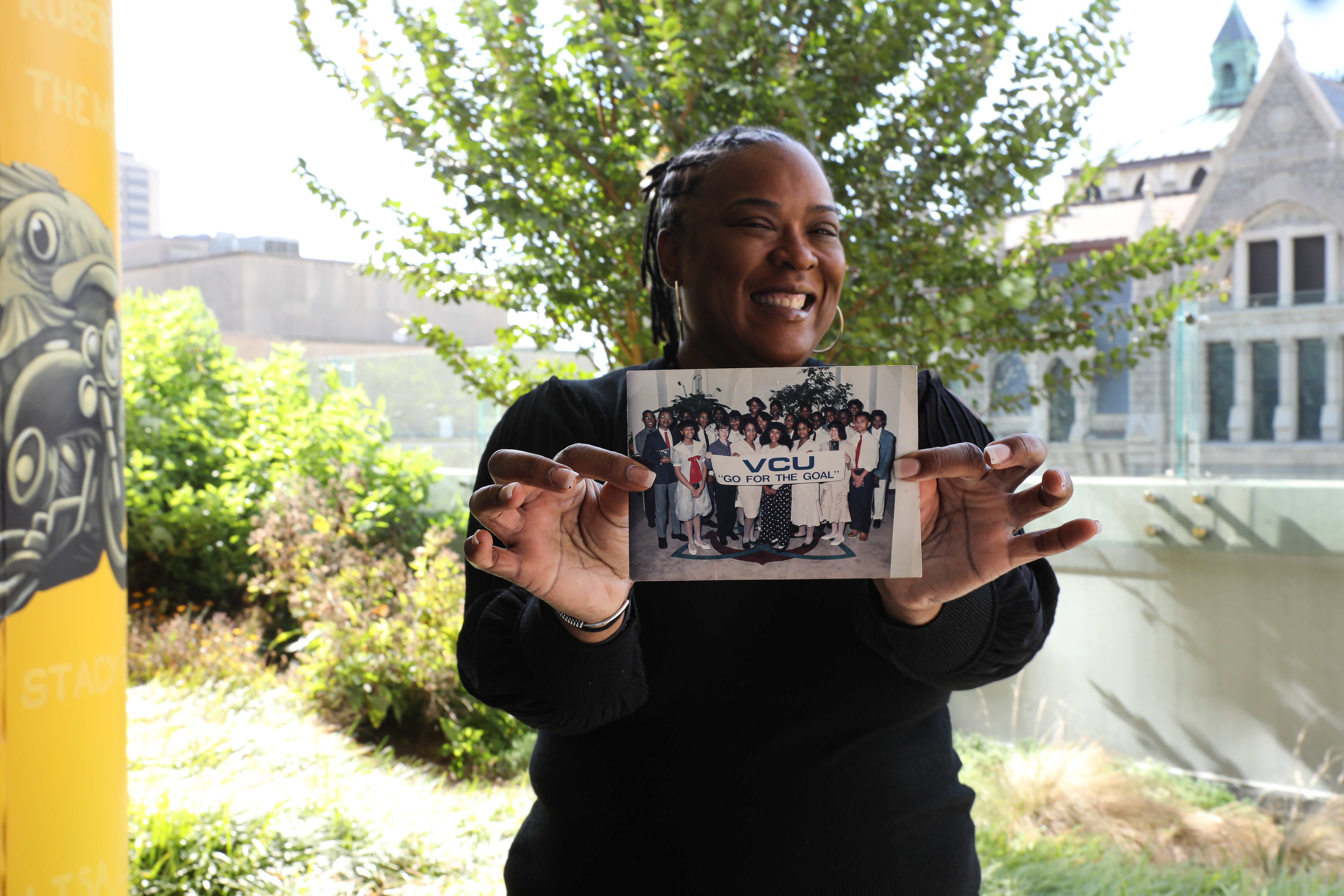 The first time Crewe visited VCU was with a group of high-achieving students from her high school in the 1990s. She can still proudly name most of the individuals in the photo she\'s holding. (Photo by Arda Athman)