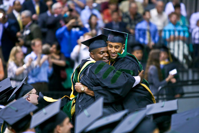 M11 Xavier Belcher hugs a classmate at graduation.