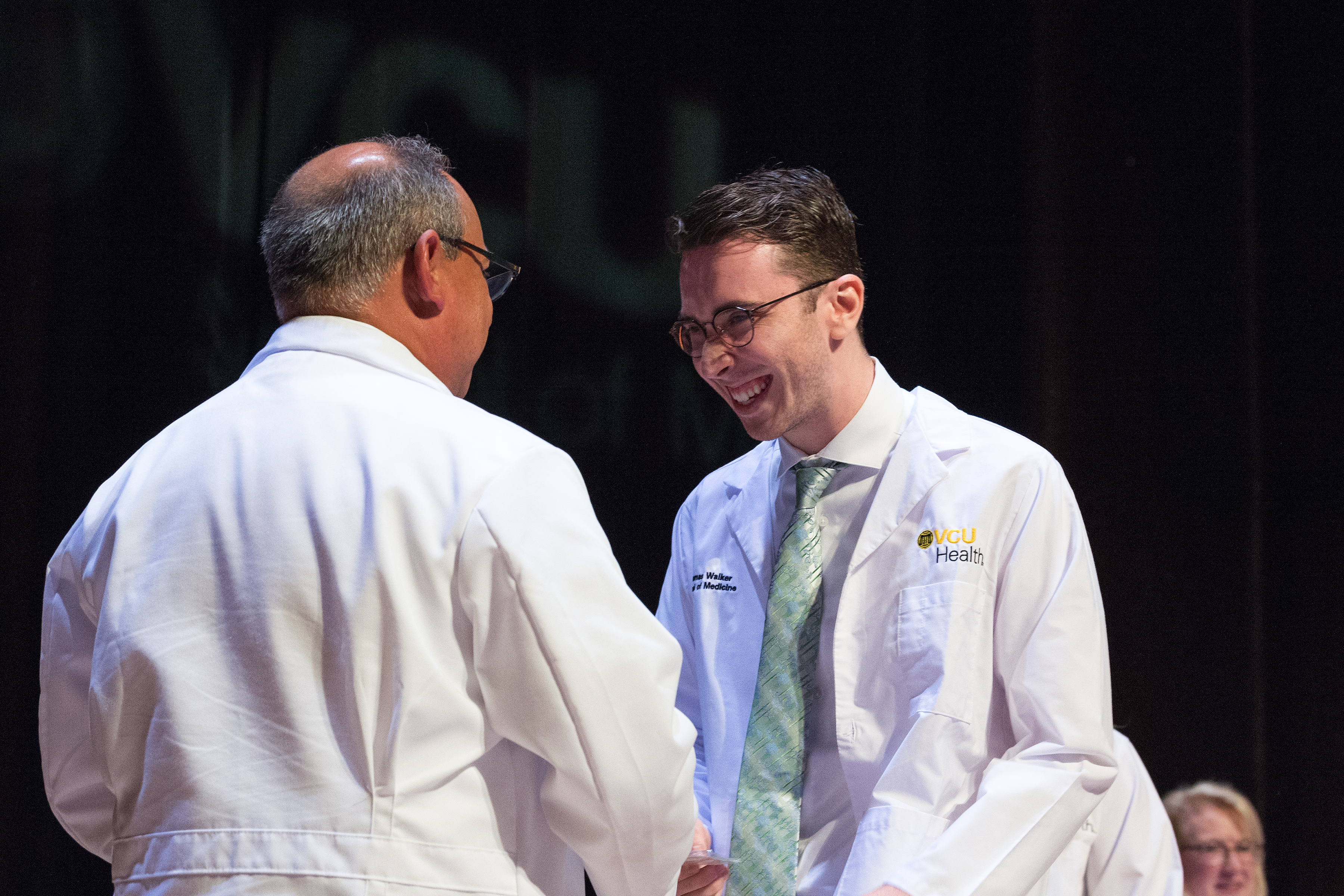 A McGlothlin scholar shakes the dean of medicine's hand