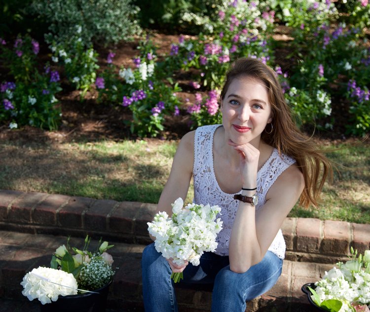 Eleanor Love, M'21, sits with a bouquet of flowers.
