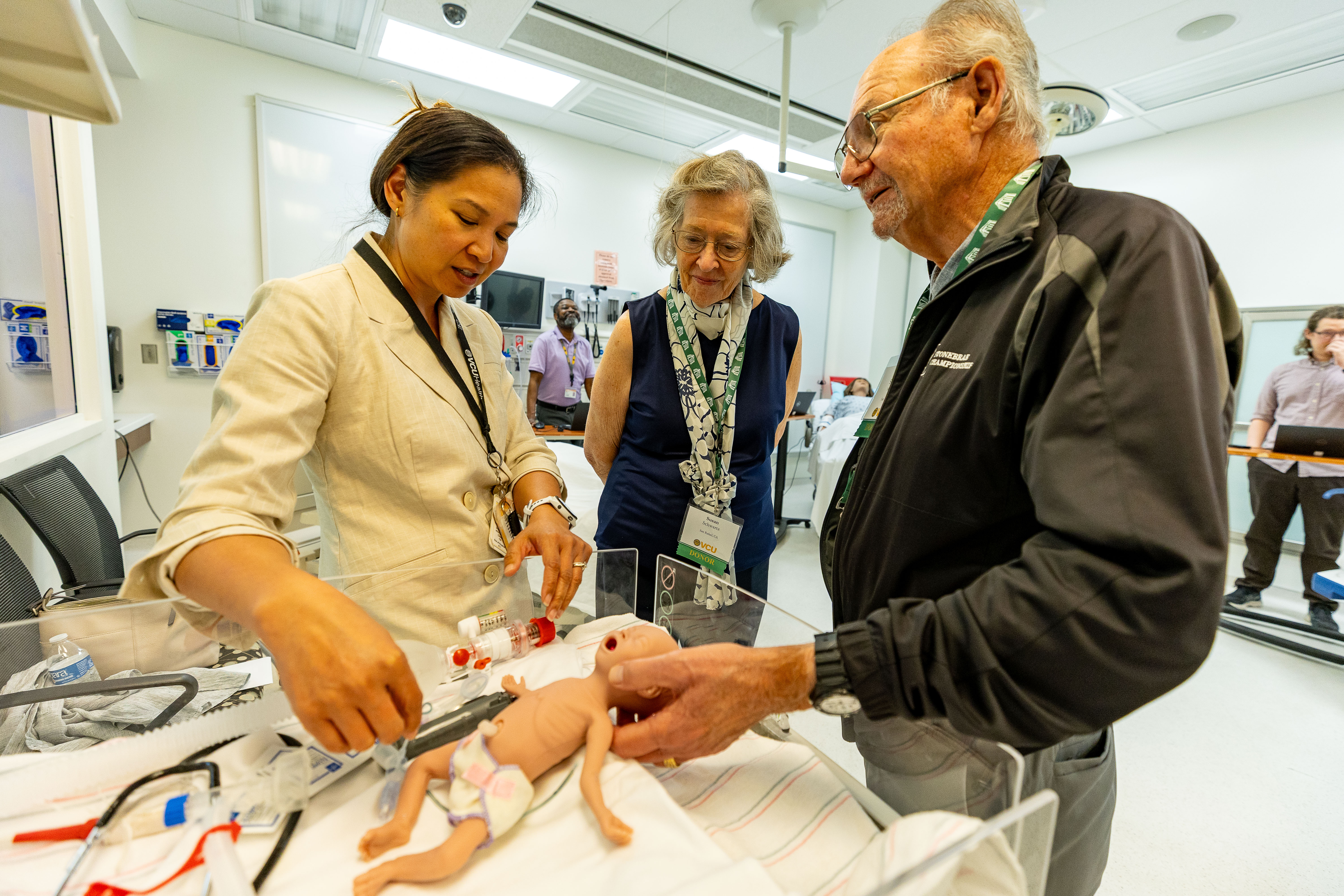  An alumnus learns about a premature baby simulation. 