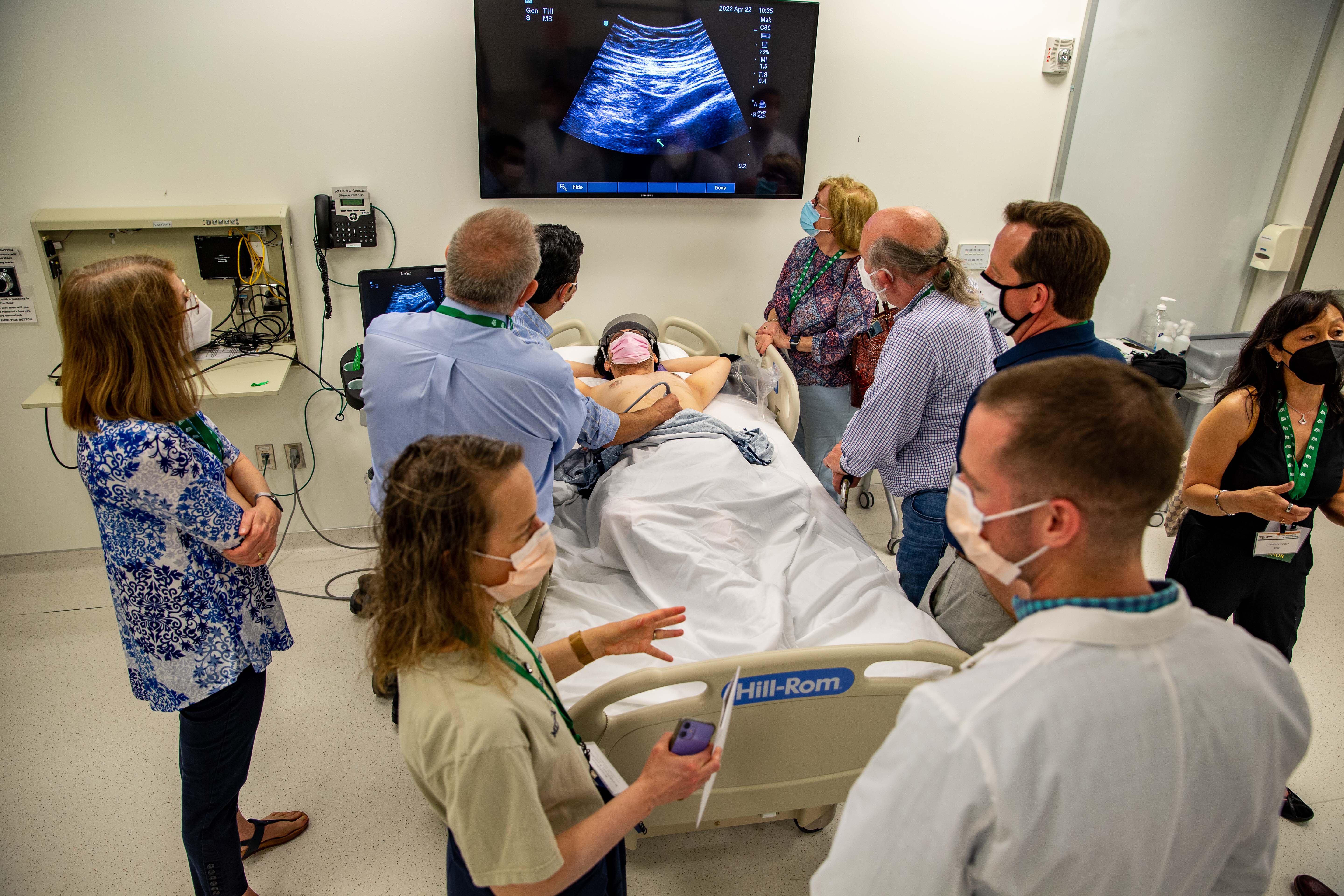  Alumni gather around standardized patient and ultrasound in simulation center 