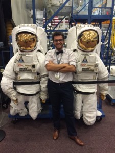 Monseur with two spacesuits at the Johnson Space Center in Houston, Texas, where he completed a clerkship in aerospace medicine.