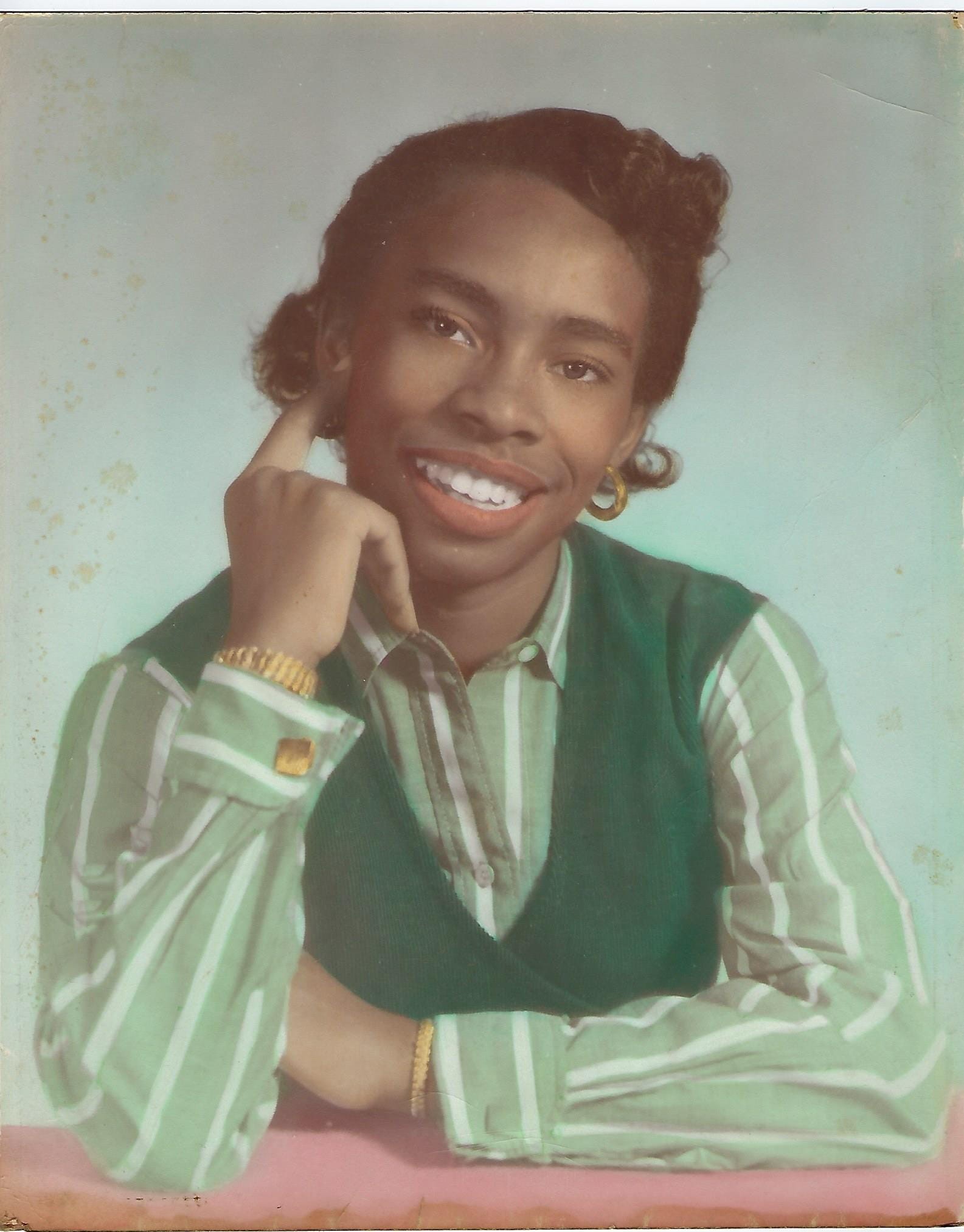 Norma Goodwin smiling in a striped shirt and sweater vest